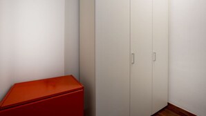 Ein Teil des Raumes mit einem weißen Kleiderschrank und einem roten Schrank.