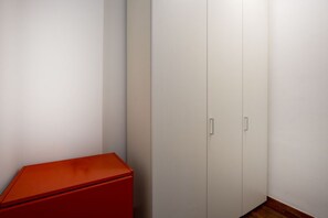 Ein Teil des Raumes mit einem weißen Kleiderschrank und einem roten Schrank.