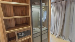 A wooden wardrobe with a built-in lock and a glass door closet with a white towel. - Locus Solus Hotel Singular (Mar del Plata)