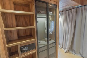 A wooden wardrobe with a built-in lock and a glass door closet with a white towel.