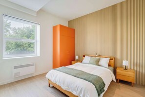 A bedroom with a bed, two bedside tables, a window, and a wardrobe. - 217 Cook - Apartment in Old Quebec (Québec)