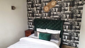 A bed with a green headboard, white bedding, and a small wooden nightstand. - Stylish home for your vacation (Agadir)