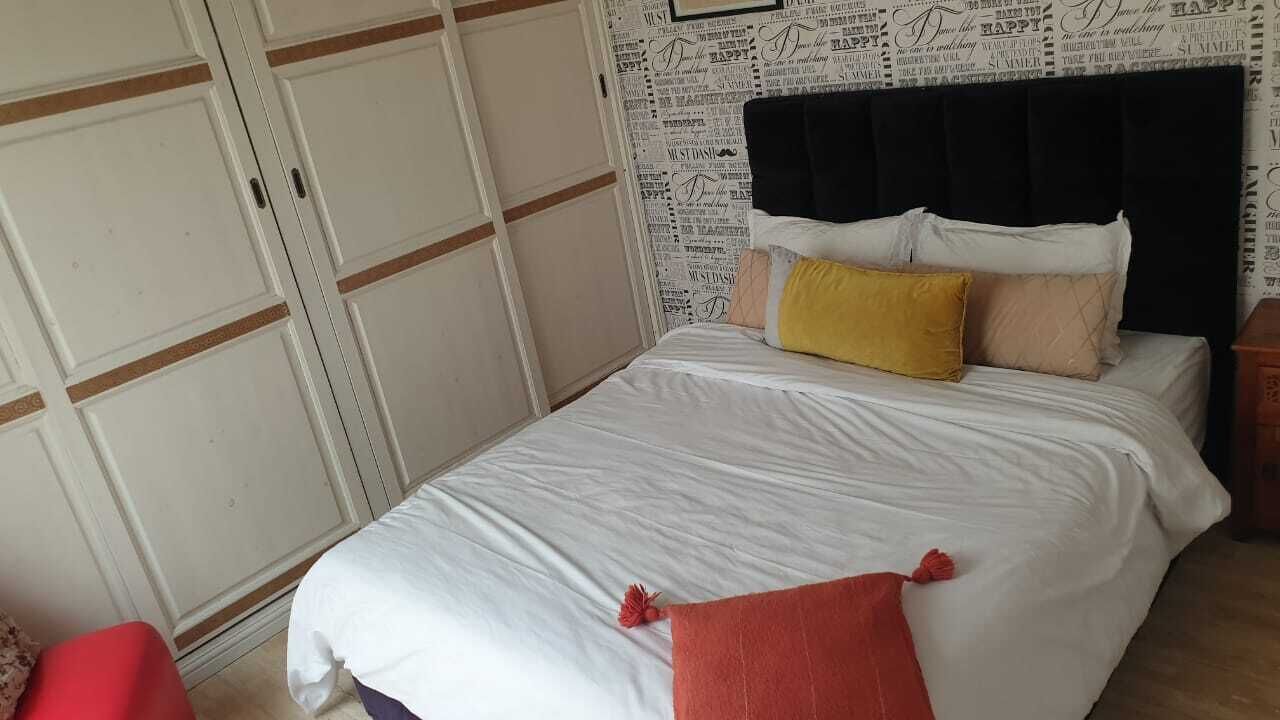 Ein Schlafzimmer mit einem Bett, einem Kleiderschrank und einer Wand mit aufgedrucktem Text.
