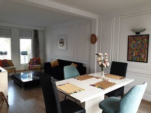 A dining area with a white table, black and teal chairs, and woven placemats. - Stylish home for your vacation (Agadir)
