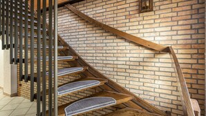 A wooden staircase with a brick wall background. - Room 'Einzelzimmer Mit Bad' with Balcony and Wi-Fi (Düsseldorf)