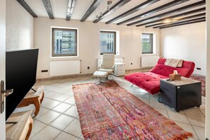 Een moderne slaapkamer met een groot bed, een televisie, een stoel en een bureau.