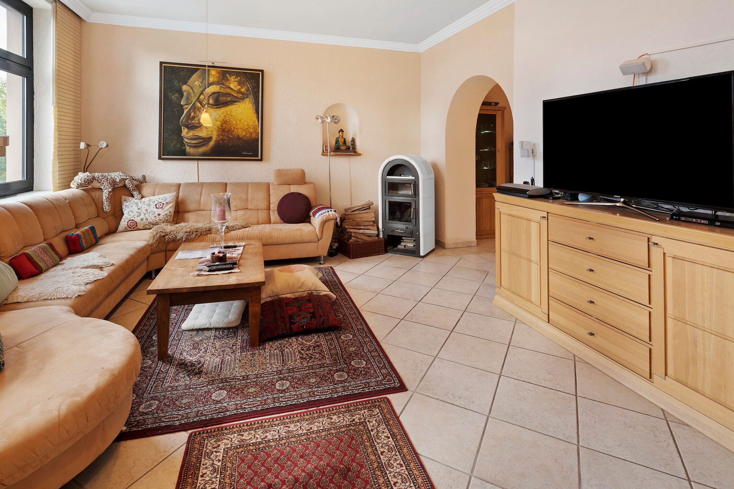 A living room with a sofa, coffee table, TV, and a fireplace.
