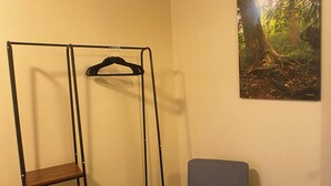 A room with a bunk bed, a chair, and a painting of a forest. - Island Street Loft - downtown convenience with proximity to local attractions! (Bryson City)