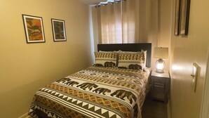 A bedroom with a bed, a nightstand, a lamp, and two framed pictures on the wall. - Island Street Loft - downtown convenience with proximity to local attractions! (Bryson City)