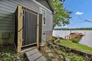A house with a wooden door, a small porch, and a dock extending into a lake. - Sunset Cove @ Wateree- 2-bedrooms, 2-bathrooms, near Wateree Creek Landing (Winnsboro)