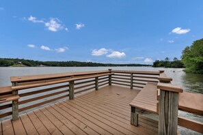 A wooden deck with a railing overlooking a calm body of water, surrounded by trees. - Sunset Cove @ Wateree- 2-bedrooms, 2-bathrooms, near Wateree Creek Landing (Winnsboro)