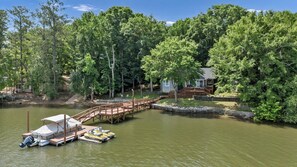 A lakeside property with a dock, a small house, and a bridge connecting to the dock. - Sunset Cove @ Wateree- 2-bedrooms, 2-bathrooms, near Wateree Creek Landing (Winnsboro)