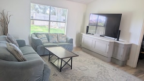 A living room with a sofa, a coffee table, a TV, and a cabinet. - Viera Home 3bed 2bath only 5min to Zoo pet-friendly (Melbourne)