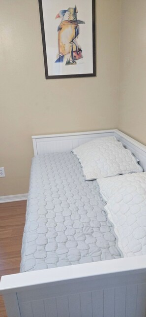 A bed with a quilted mattress and pillows, a white headboard, and a framed picture on the wall. - Viera Home 3bed 2bath only 5min to Zoo pet-friendly (Melbourne)