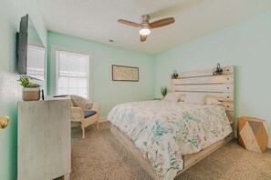 A bedroom with a bed, a desk, a chair, a ceiling fan, and a window. - JL #061 E Z Livin - Hot Tub - Close to beach (Kill Devil Hills)