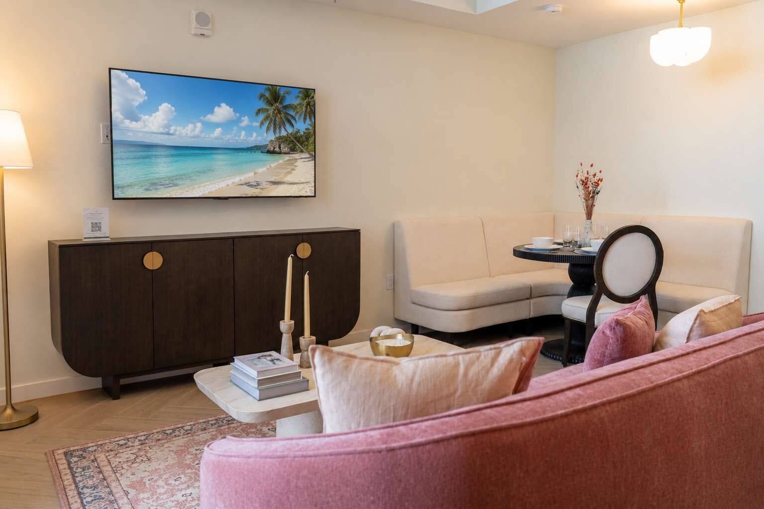 A living room with a sofa, a side table, a cabinet, a painting of a beach, and a lamp.