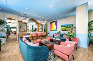 Ein großzügiger Loungebereich mit Bar, Sitzgelegenheiten und einem großen Wandbild.