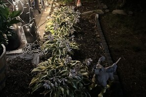 A garden pathway lined with potted plants and a decorative sculpture. - SAGE Boutique Retreat • Sleeps 6 (Burrillville)