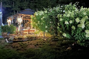 A building with a wooden structure, surrounded by a garden with hydrangea bushes.