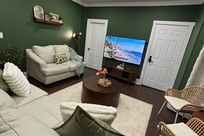 A living room with a sofa, a coffee table, and a television.