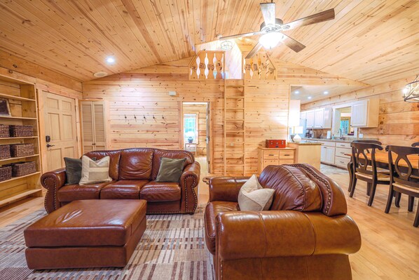 A wooden interior with a leather sofa set, a dining area, and a kitchen. - Luxury Cabin, Family Friendly, Great WiFi & Location, EV Charger (Highlands)