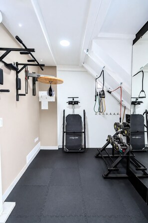 A gym with exercise equipment, a punching bag, and a mirror. - Prado Centro #2 Luxury Suite - Jacuzzi & Balcony (Medellín)