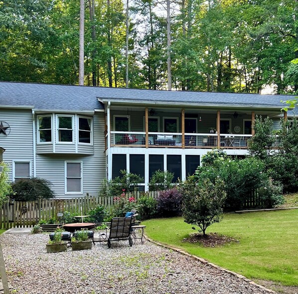 A two-story house with a covered porch and a fenced yard.