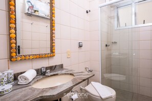 Ein Badezimmer mit Marmorwaschbecken, Toilette und Dusche.