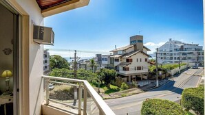 Área residencial com varanda voltada para uma rua com casas e vegetação.