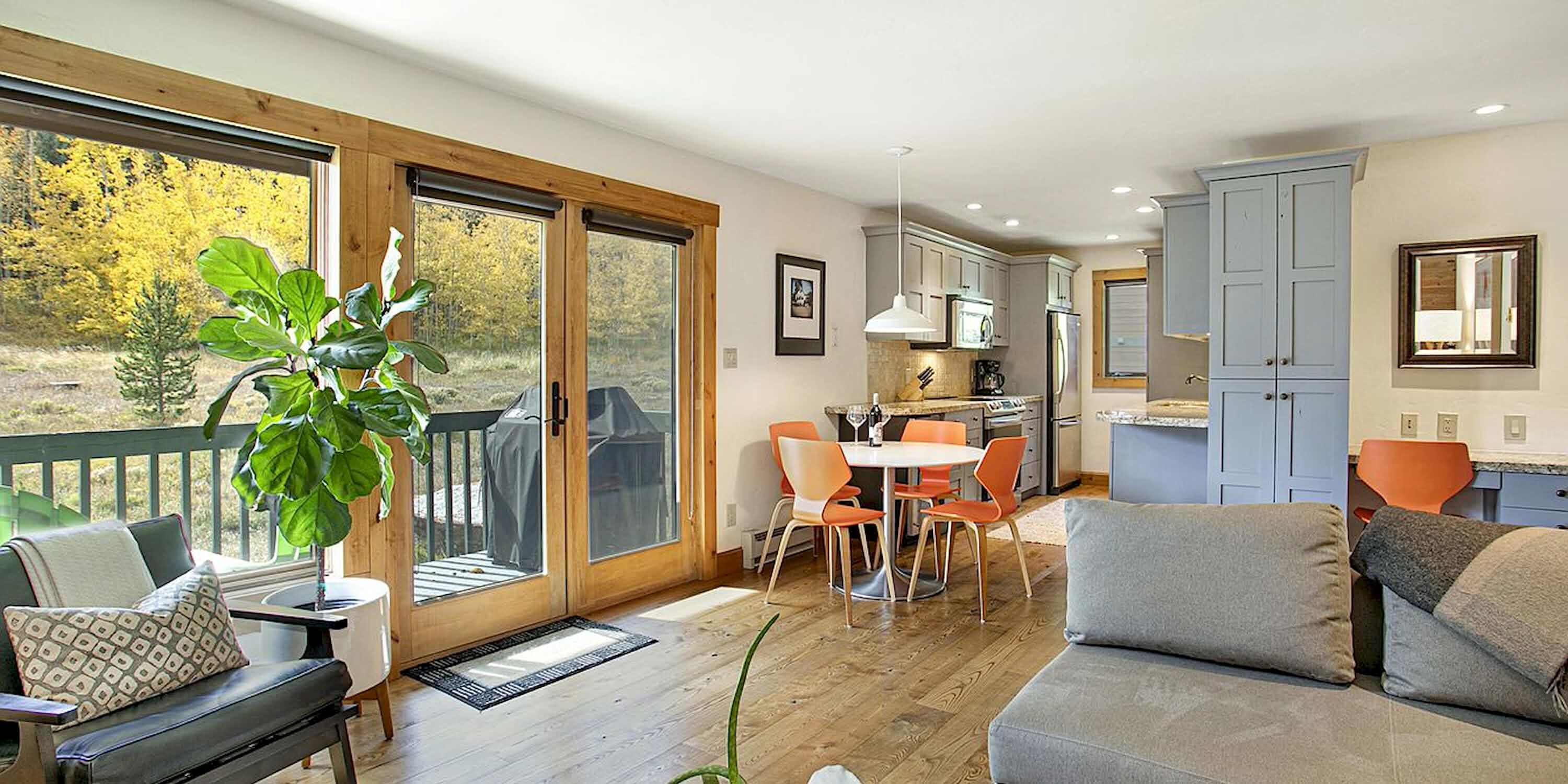 A cozy living room with a fireplace, a dining area, and a kitchen with modern appliances.