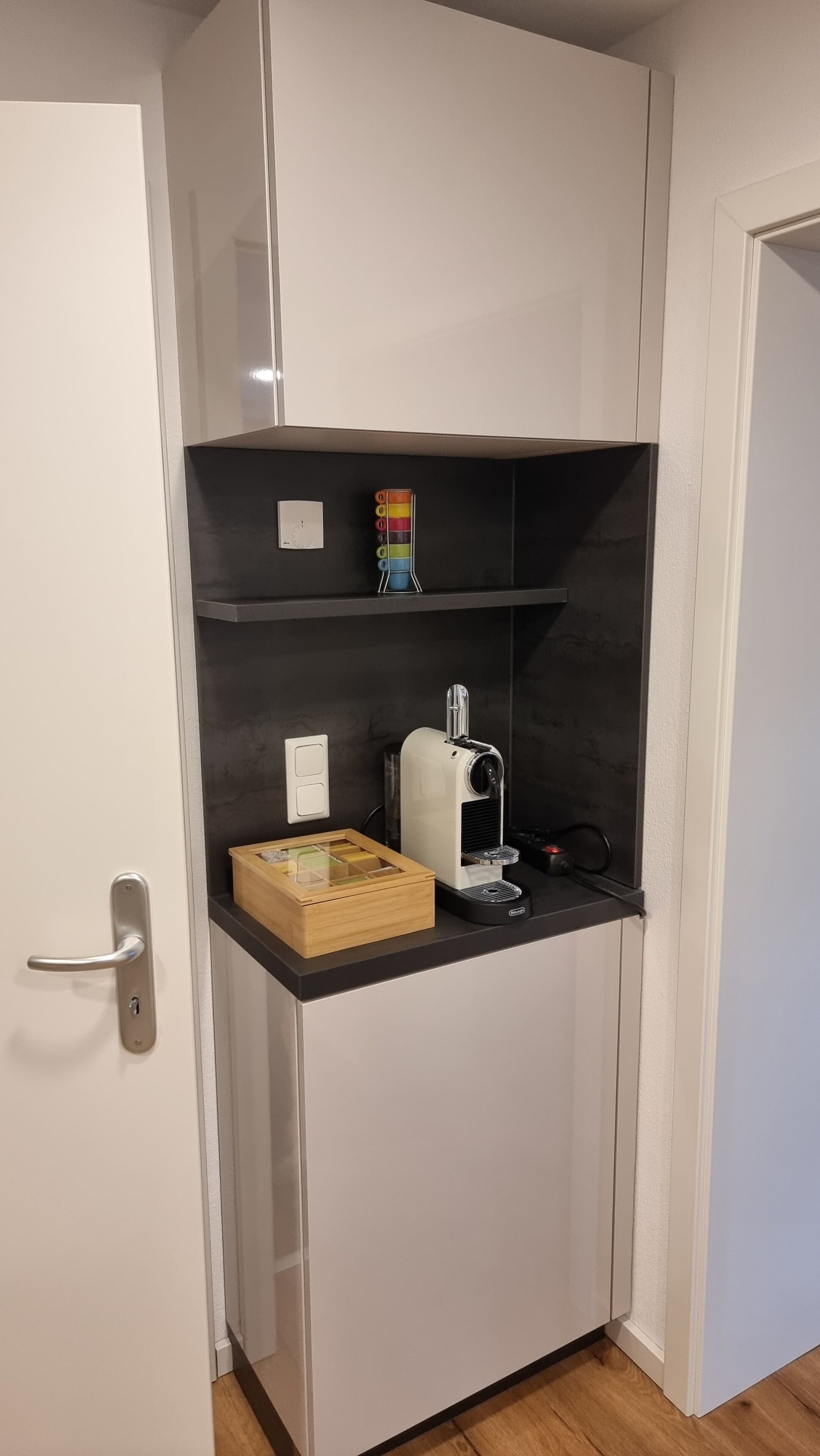 Une petite cuisine équipée d’un four à micro-ondes, d’une machine à café et d’une petite boîte en bois.
