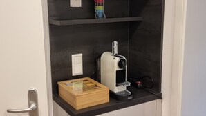 A compact kitchenette with a microwave, a coffee maker, and a small wooden box. - LIBORIA Alpine Getaway: Stunning Vacation Rental with a Balcony (Riegsee)
