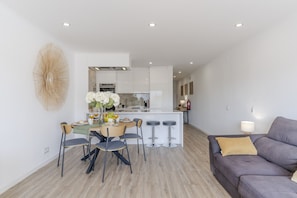 A modern apartment with a dining area, kitchen, and living space.