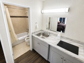 Kombinasi shower/bathtub, handuk,  dan tisu toilet