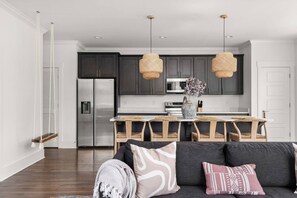 A modern kitchen with dark cabinets, stainless steel appliances, and a central island. - Soak it up in East! 8 beds 3.5 bath Garage incl! (Nashville)