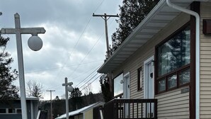 A snow-covered pathway leading to a building with a porch and a staircase. - Cozy 1BR hotel room, Hamilton - #341 Rode-A-Syde (Hamilton)