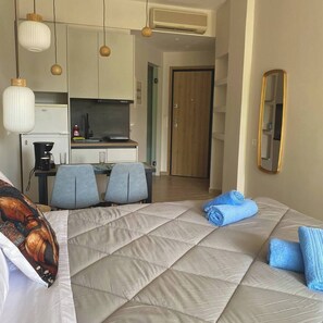 Ein Hotelzimmer mit Bett, Schreibtisch und einer Küchenzeile.