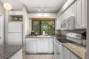 A kitchen with white cabinets, a built-in microwave, a stove, and a dishwasher. - Wailea Ekahi 52D - Wailea 1BR Condo, Garden Lanai, AC, Island Luxury Beach Condo (Kihei)