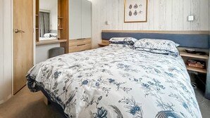 Una camera da letto con un letto, un comodino, uno specchio e un armadio.