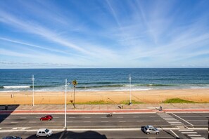 A beach view with a road in the foreground, a clear sky, and the ocean in the background. - Incredible Ocean View•Swimming pools•Academy•Wi-Fi•Vacancy (Salvador)