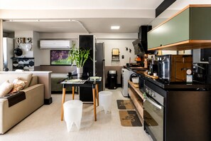 A modern kitchen with a built-in oven, a coffee machine, and a dining area with a table and chairs. - Incredible Ocean View•Swimming pools•Academy•Wi-Fi•Vacancy (Salvador)