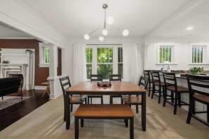 A dining area with a wooden table, chairs, and a chandelier.