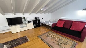 Una sala de estar moderna con una televisión de pantalla plana, un sofá, una mesa de centro y un tapete estampado.