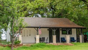 Ein kleines Gebäude mit einer Veranda, einer US-amerikanischen Flagge und Außenbestuhlung.