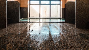 A wet floor in a room with a large window, wooden walls, and a ceiling with recessed lighting. - Hotel Area One Ise Inter (Ise)