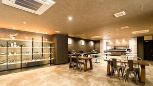 A restaurant with a bar area, seating, and a display of items on shelves. - Hotel Area One Ise Inter (Ise)