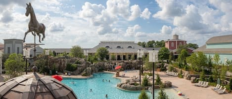 Um resort com uma grande piscina, uma estátua de cavalo e diversos edifícios.