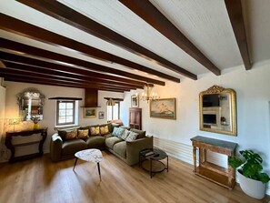 Una sala acogedora con un sofá modular, una mesita redonda y un aparador de madera.