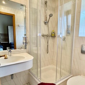 A bathroom with a glass-enclosed shower, a sink, and a toilet. - Hotel Pension Pamina (Berlin)