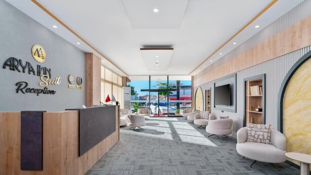 A modern reception area with a reception desk, seating area, and large windows offering a view of the outside. - ARYA INN SUİT  (Serik)